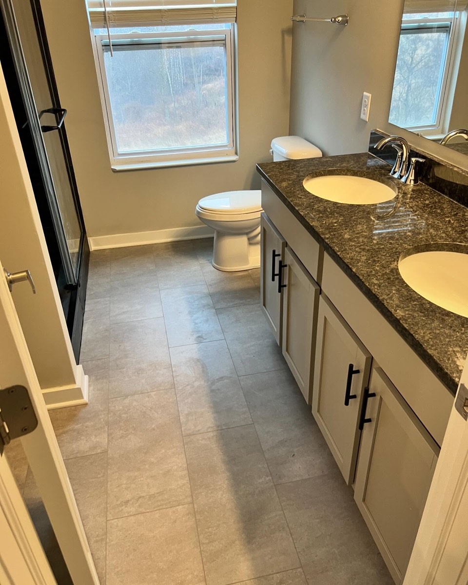 Bathroom remodel with granite double vanity and walk-in tile shower with bench seat