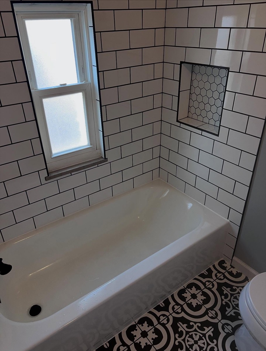 Subway-tile tub surround with hexagon-tile niche and frosted window