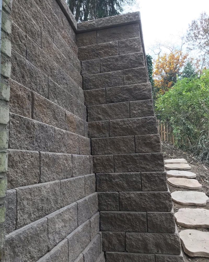 Tall Versa-Lok block retaining wall with stepping-stone path