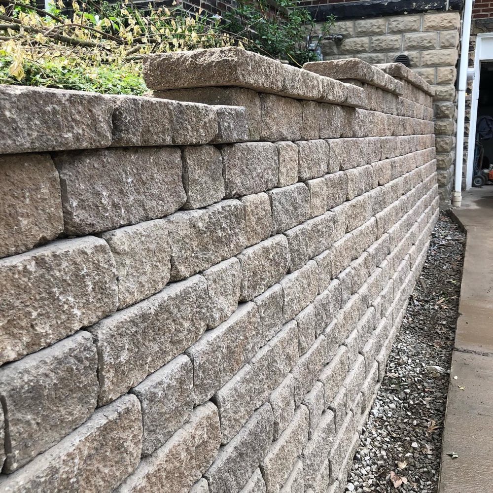 Versa-Lok weathered-harmony block retaining wall along a walkway