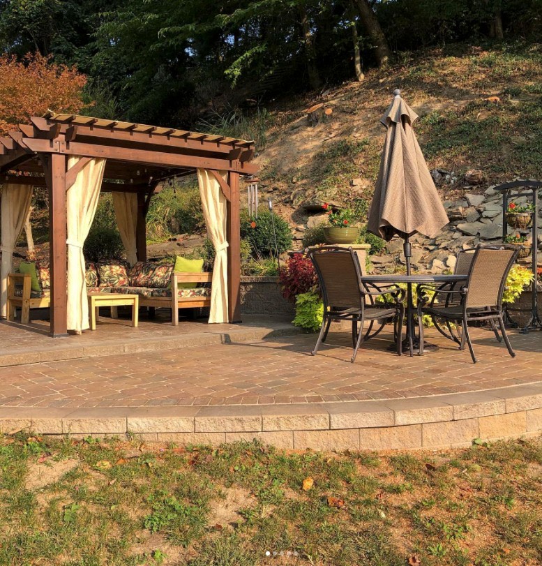 Raised paver patio with pergola seating area and outdoor dining set